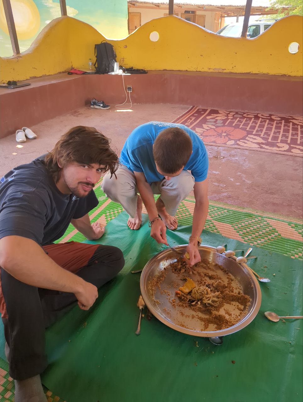 Roger and Jaume competing to see who can eat more Thiebou djen <em>rouge</em>